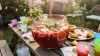Pichet de sangria rouge avec fruits et glaçons en terrasse
