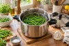 Haricots verts cuits dans le panier d’une cocotte-minute ouverte.